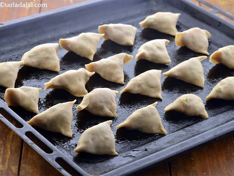 Step 29 – Arrange the <strong>atta ke samose</strong> on a greased baking tray.