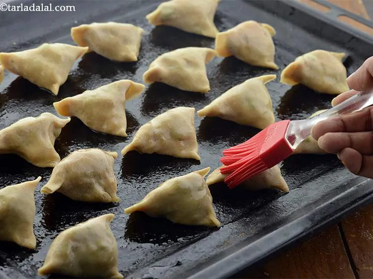 Step 30 – Brush the <strong>samosas</strong> with oil.