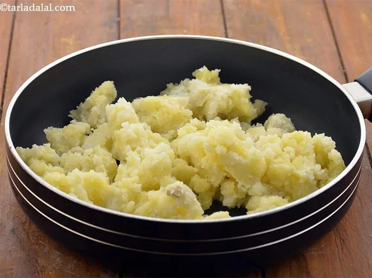 Step 14 – When the seeds crackle, add the potatoes. We have boiled the potatoes in a pressure …