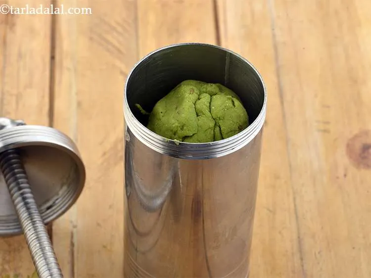 Step 10 – Press the dough into a <strong>murukku</strong> &ldquo;press&rdquo; and cover it with the lid.