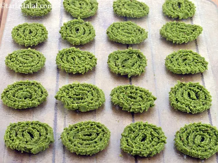 Step 11 – Press out 50 mm. (2&rdquo;) diameter round swirls of <strong>baked palak jowar murukku recipe | …