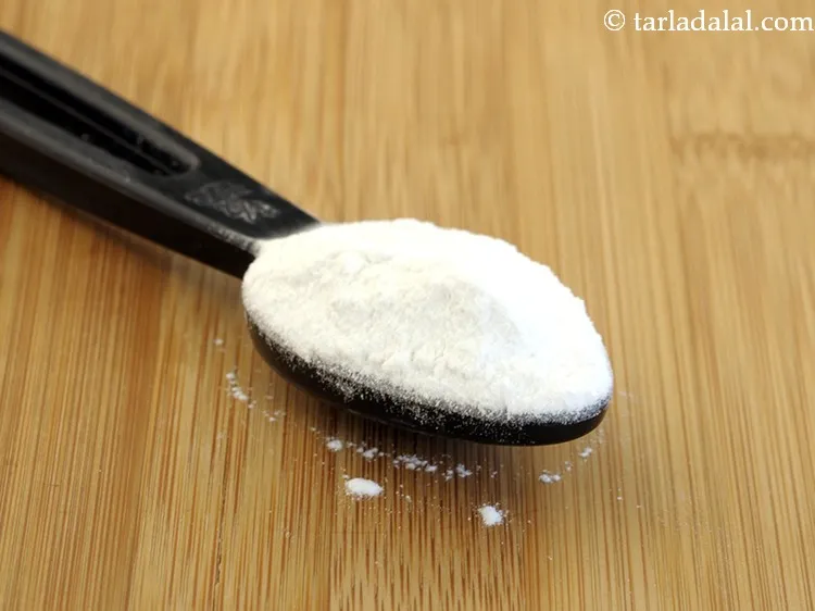 स्टेप 9 – १ टी-स्पून&nbsp;<a href=""https://www.tarladalal.com/glossary-baking-powder-hindi-425i"">बेकिंग पाउडर</a>&nbsp;डालें।&nbsp;इससे केक को फूलने में मदद मिलेगी।