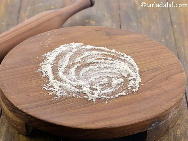 स्टेप 17 – रोलिंग सतह पर थोड़ा आटा छिड़कें। यह आटे को रोलिंग …