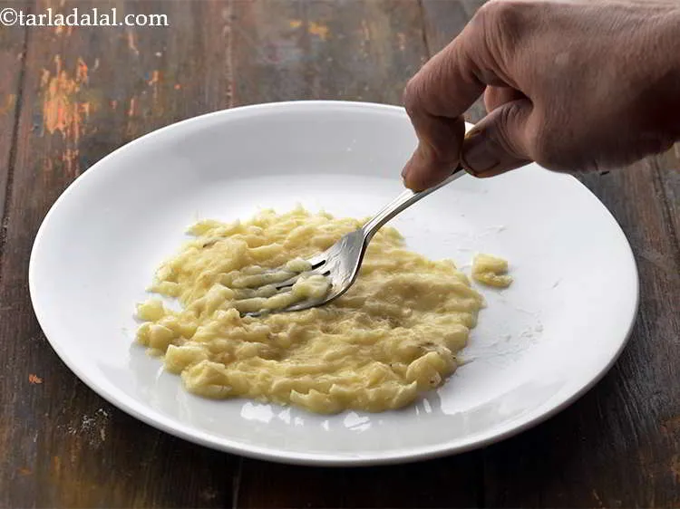 स्टेप 3 – एक छोटी प्लेट पर पका हुआ केला लें और उसे …