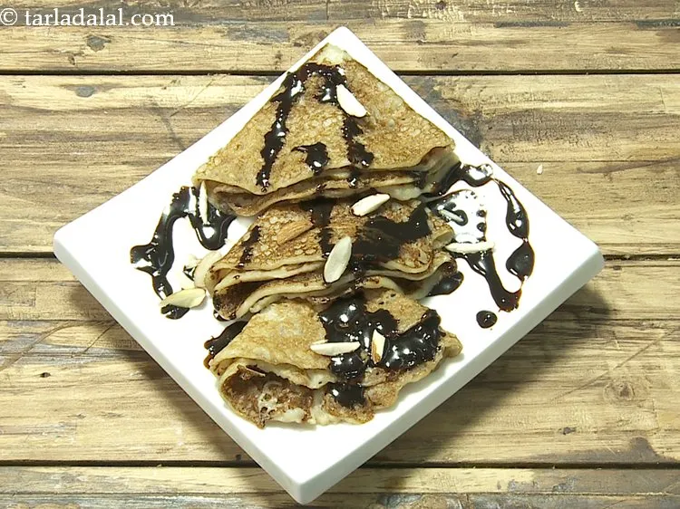 Step 18 – Garnish <strong>banana pancakes with chocolate sauce</strong> with almond slivers.