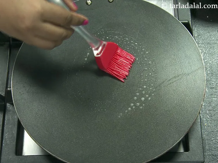 Step 7 – For cooking the <strong>banana pancakes</strong>, heat a non-stick tava (griddle) and grease it using &frac14; …