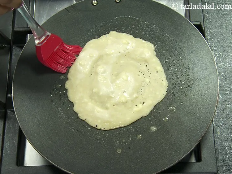 Step 9 – Cook the <strong>eggless banana pancake</strong> on a medium flame using &frac14; tsp of butter.