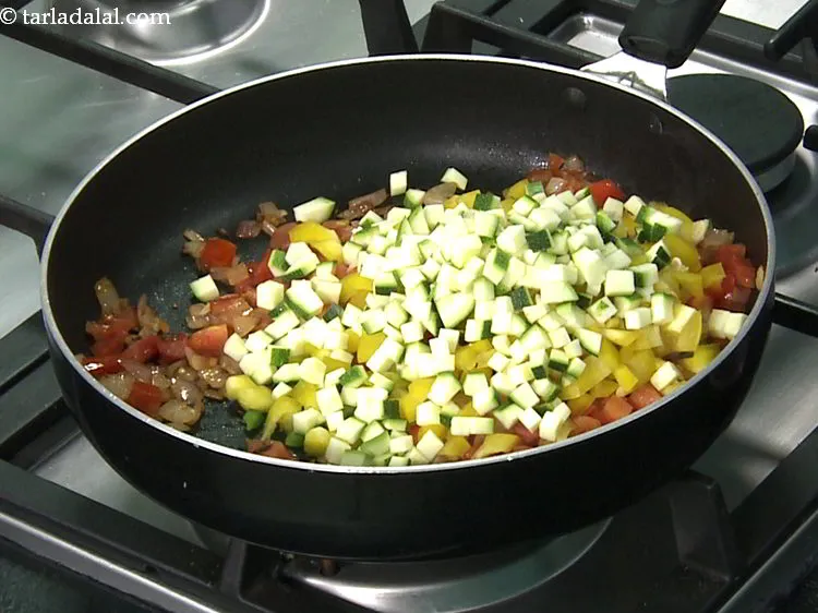 स्टेप 18 – कटी हुई ज़ूकिनी डालें।