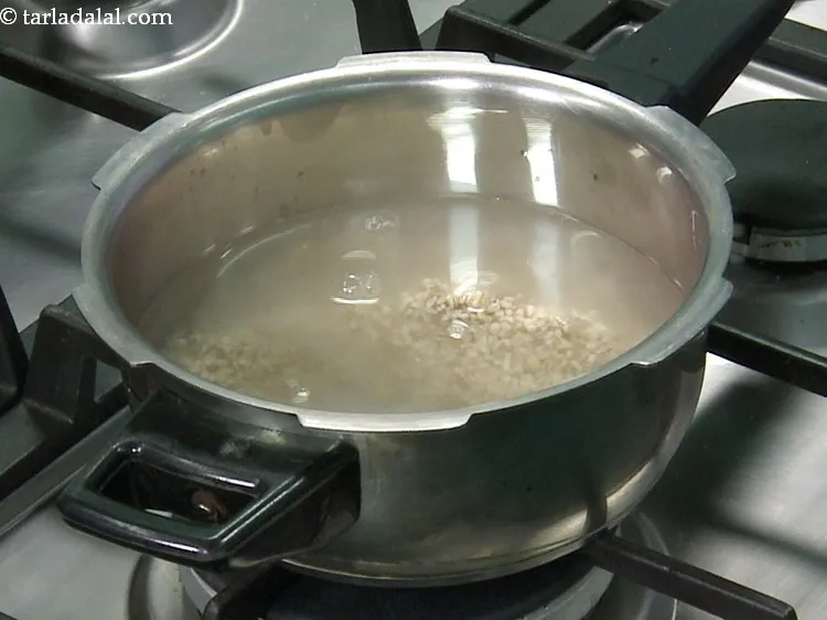 स्टेप 7 – प्रेशर कुकर में १ १/२ कप ताज़ा पानी डालें।