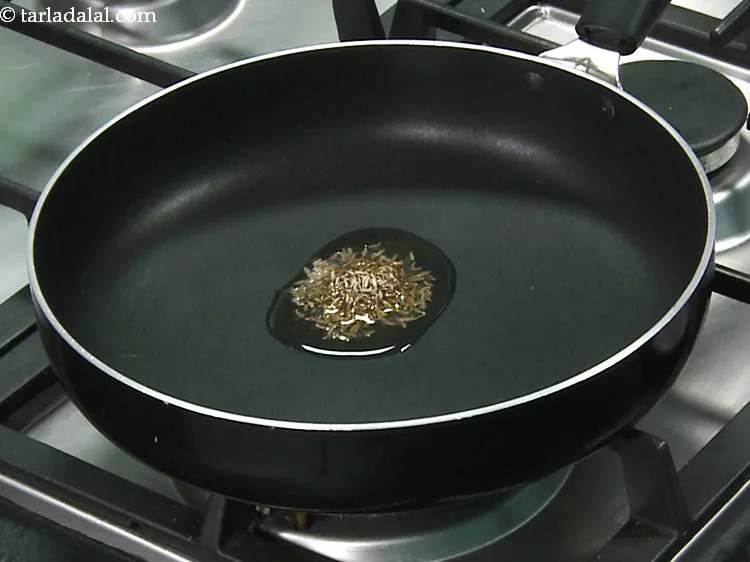 स्टेप 10 – तेल गरम होने पर जीरा डालें।