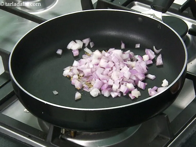 स्टेप 11 – जब जीरा चटकने लगे तो प्याज़ डालें।