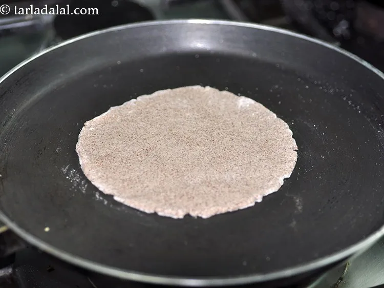 स्टेप 14 – जब नॉन स्टिक तवा गरम हो जाए तो रागी भाकरी …