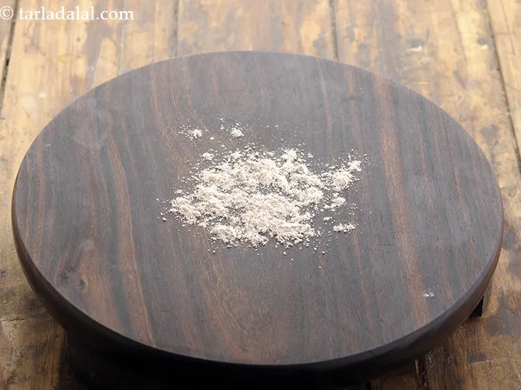 स्टेप 10 – रोलिंग बोर्ड पर थोड़ा रागी का आटा छिड़कें ताकि रागी …