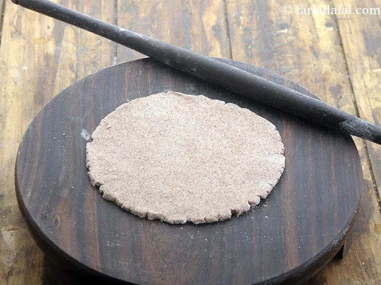 स्टेप 12 – थोड़े सूखे रागी का आटे का प्रयोग करके ५&rdquo; व्यास …