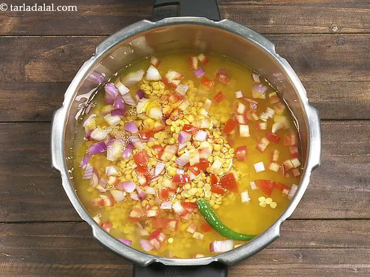Step 9 – Add turmeric powder and 2 cups of water in a pressure cooker.