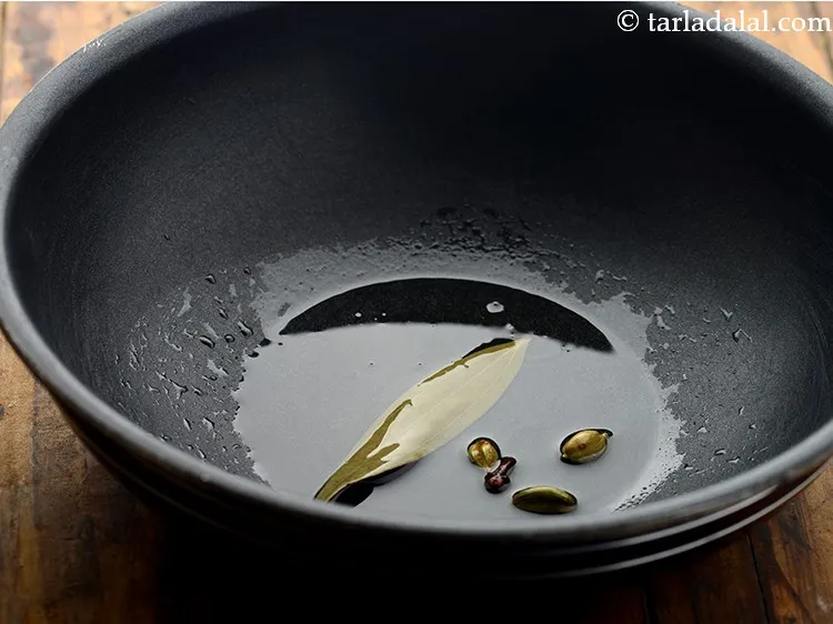 Step 13 – Once the oil is hot, add the cardamom, cloves and saut&eacute; on a medium flame …
