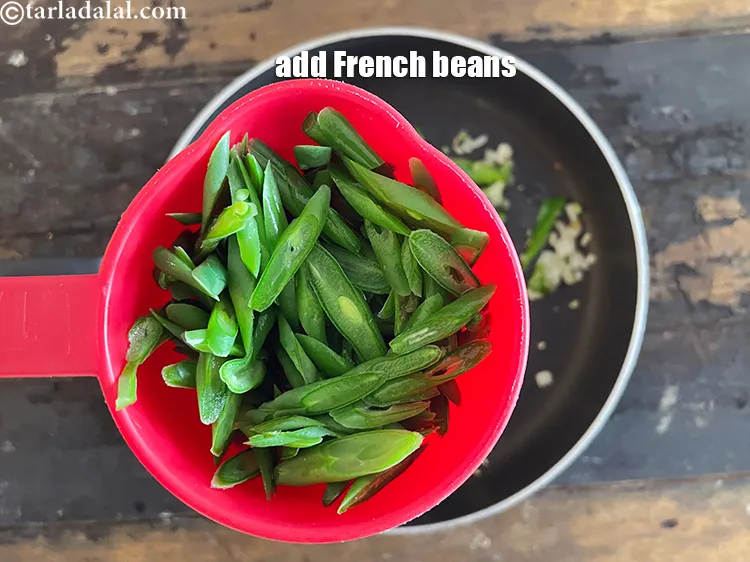 Step 15 – Add 1/2 cup&nbsp;<a href="https://www.tarladalal.com/glossary-french-beans-fansi-196i">french beans</a>&nbsp;, diagonally cut and blanched.