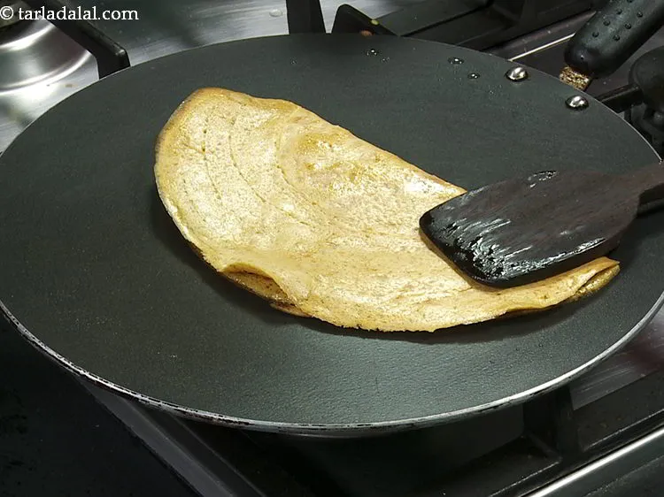 Step 17 – Fold the <strong>besan pudla</strong> to make a semi-circle.