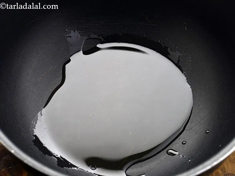 Step 14 – To prepare<strong> raswala bhaat na muthia</strong>, heat the oil in a deep pan.