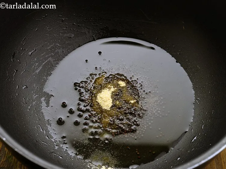 Step 16 – When the seeds crackle, add the asafoetida.