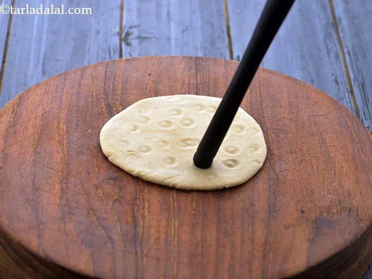 Step 13 – Once rolled, make small groves evenly over the rolled <strong>Gujarati bhakri</strong> using the edge of …