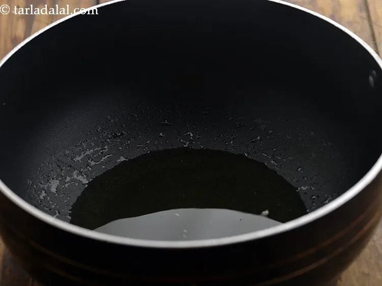 Step 17 – To prepare <strong>Maharashtrian style stuffed brinjals</strong>, heat the oil in a deep non- stick pan.