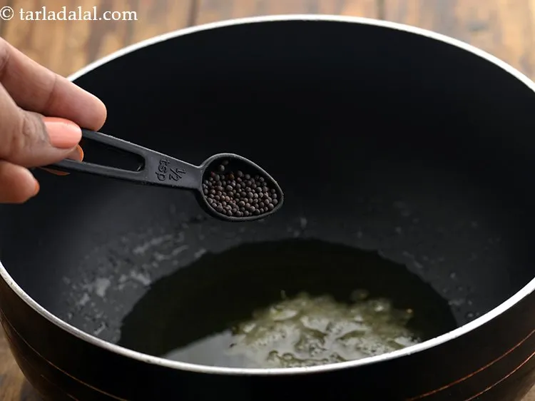 Step 18 – Once the oil is hot, add mustard seeds.