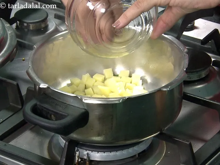 Step 28 – Add all the vegetables one by one. First add 1/2 cup&nbsp;<a href="https://www.tarladalal.com/glossary-chopped-potatoes-787i">chopped potatoes</a>.