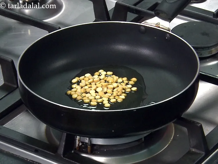 Step 7 – Add all the ingredients one by one. First add 1 tbsp&nbsp;<a href="https://www.tarladalal.com/glossary-chana-dal-split-bengal-gram-285i">chana dal (split bengal …