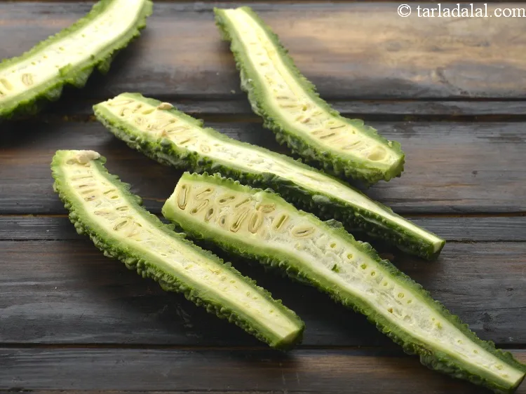 Step 3 – We first need 5 karela. Wash them and cut into halves vertically. You will get …