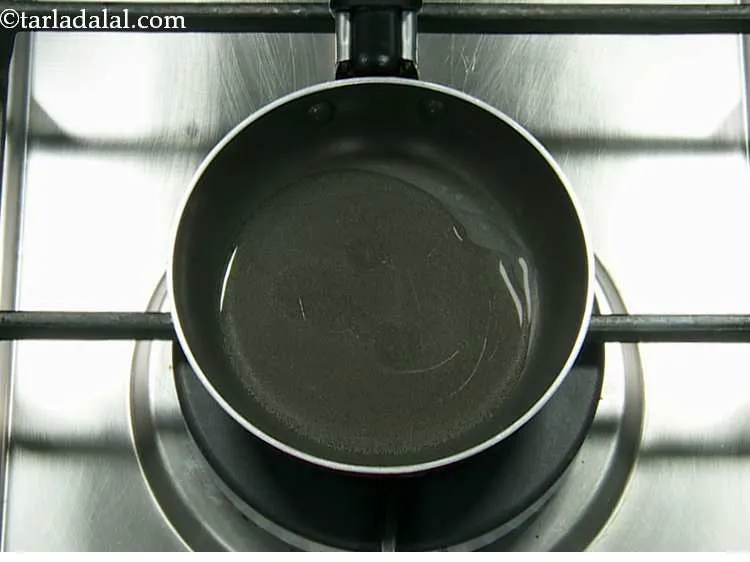 स्टेप 13 – एक छोटे नॉन-स्टिक पैन में शेष १ टेबल-स्पून तेल गरम …