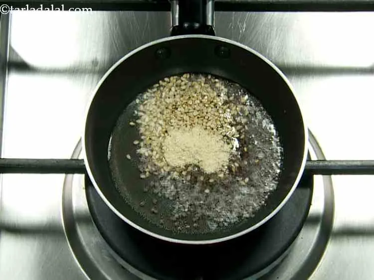 स्टेप 14 – सरसों, तिल और हींग डालें।