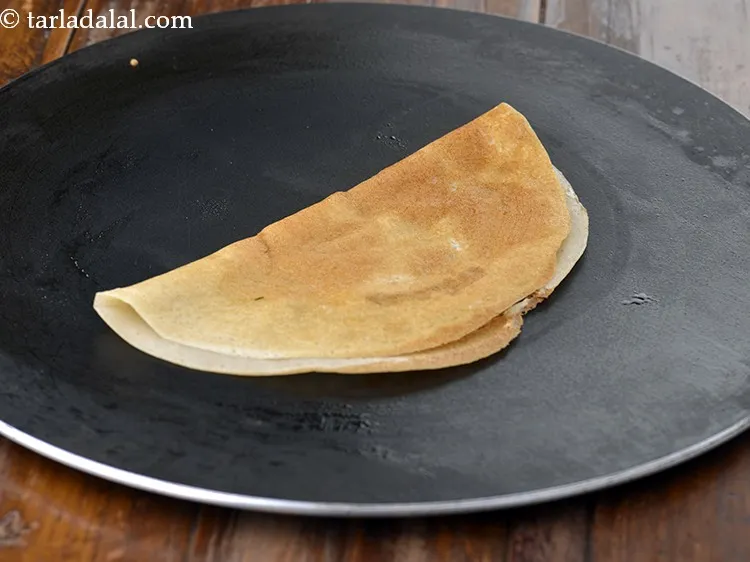 Step 14 – Fold the dosa into a semicircle. For a variation you can prepare an aloo masala …