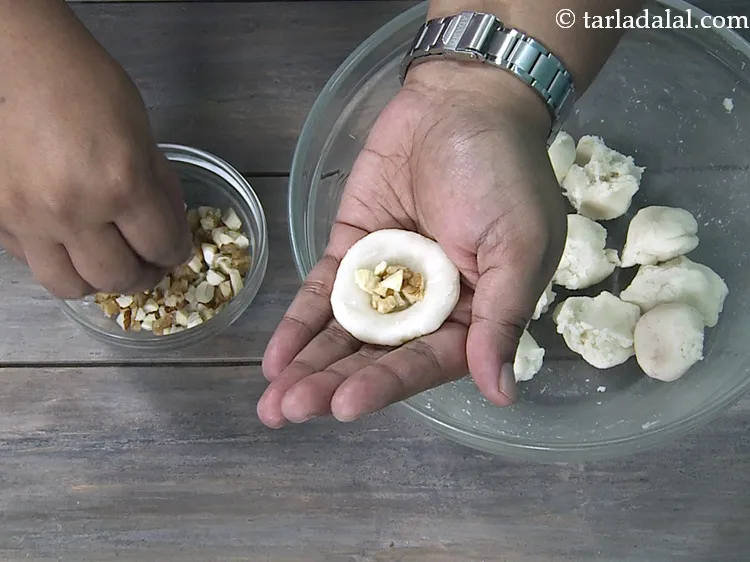 Step 19 – Put &frac12; tsp of <a href="https://www.tarladalal.com/glossary-chopped-mixed-nuts-928i">chopped mixed nuts</a>&nbsp; in the centre.&nbsp;