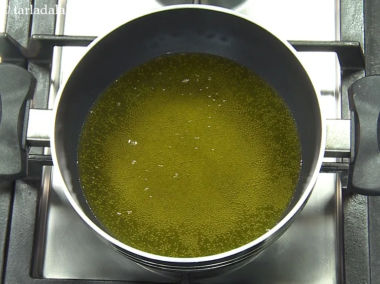 Step 24 – Heat <a href="https://www.tarladalal.com/glossary-ghee-245i">ghee</a>&nbsp;for deep-frying in a deep non-stick pan.