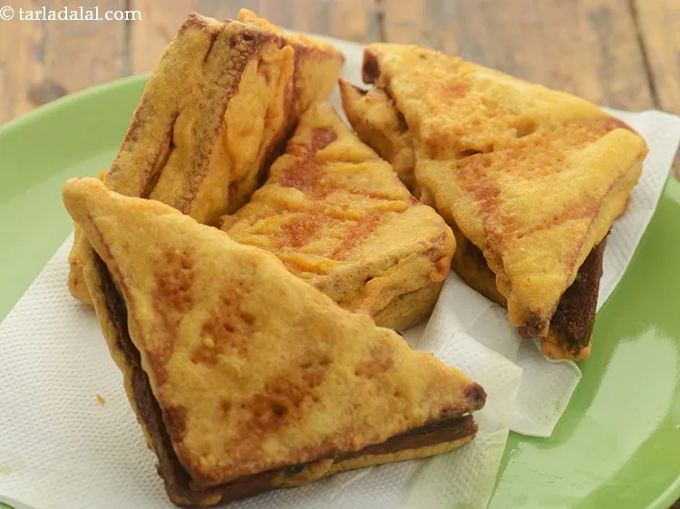 Step 25 – Remove the paneer stuffed bread pakodas using a slotted spoon and drain on absorbent paper …