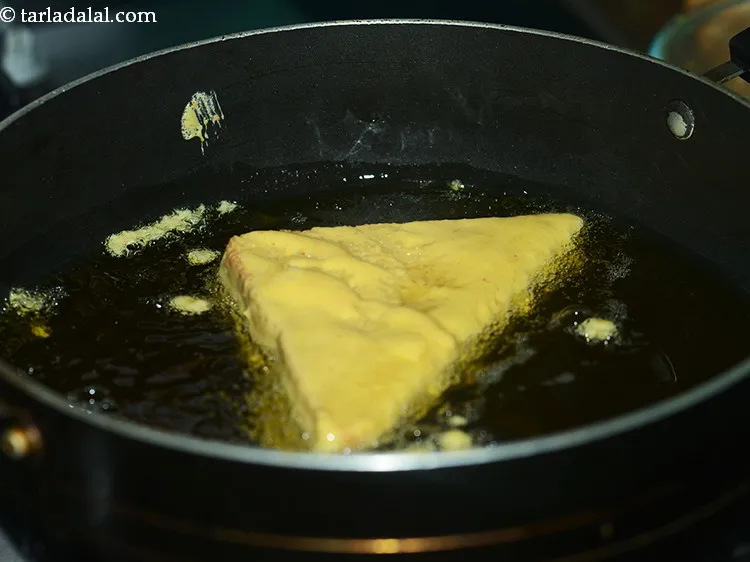 Step 22 – To deep-fry <strong>bread pakora</strong>, heat the oil in a deep non-stick kadhai, dip bread pakoda …