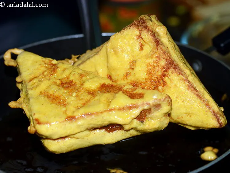 Step 24 – Flip and fry to cook the cottage cheese bread pakoras evenly from all sides.