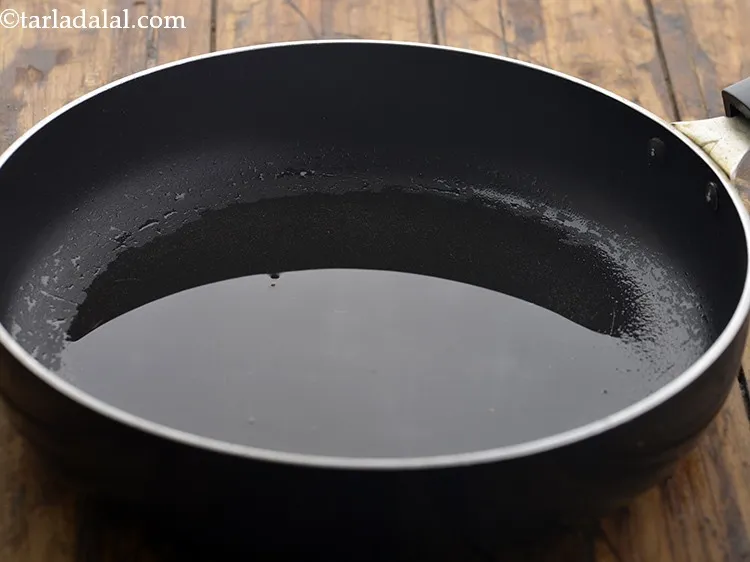 Step 4 – For preparring bread upma, heat the oil in a broad non-stick pan.