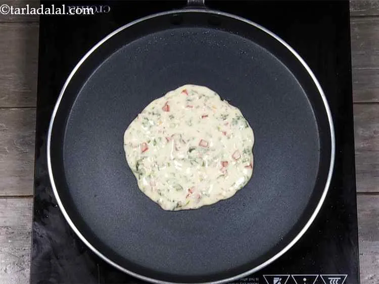 Step 16 – <p>Pour a ladleful of the batter on the tava (griddle), spread in a circular motion …