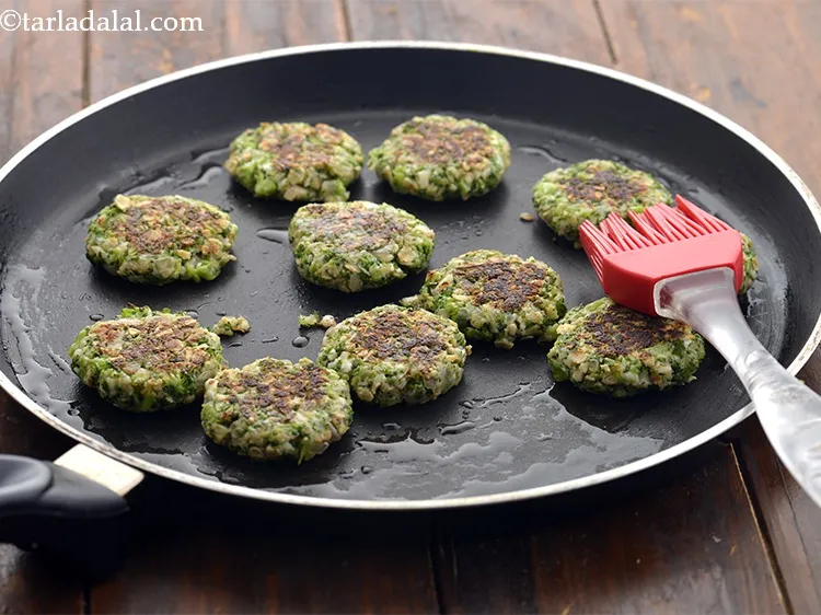 स्टेप 22 – पलटें, &frac12; टीस्पून तेल डालें और सभी टिक्की को दोनों …