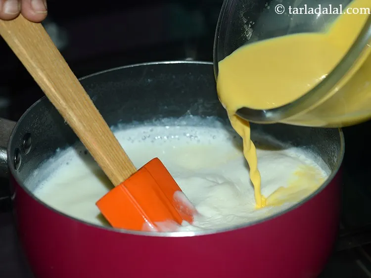 स्टेप 7 – जब इसमें एक उबाल आ जाए, तो कस्टर्ड-दूध का मिश्रण …