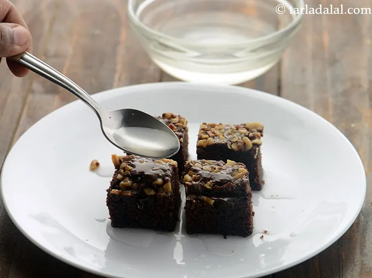 स्टेप 16 – प्रत्येक ब्राउनी के उपर तैयार चीनी सिरप के डालें। १० …