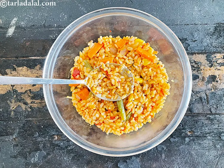 Step 80 – Push down with the back of a spoon to make a layer off the rice.