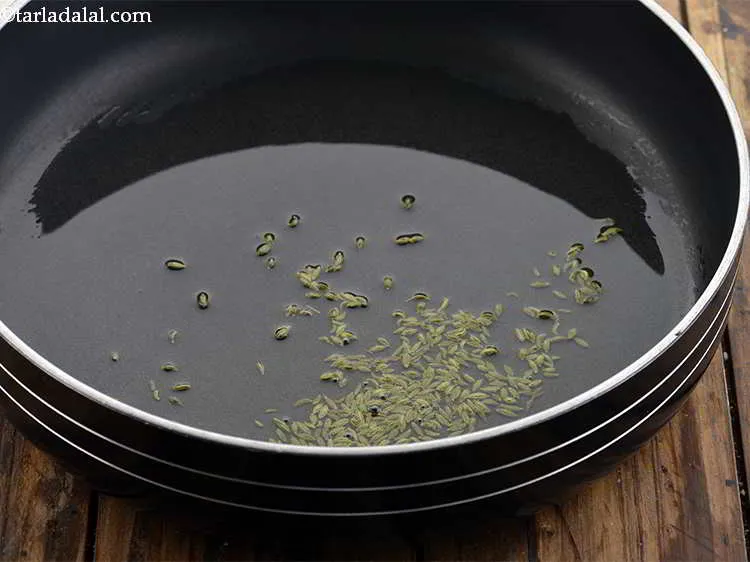 Step 12 – Heat the oil in a broad non-stick pan, add the fennel seeds.