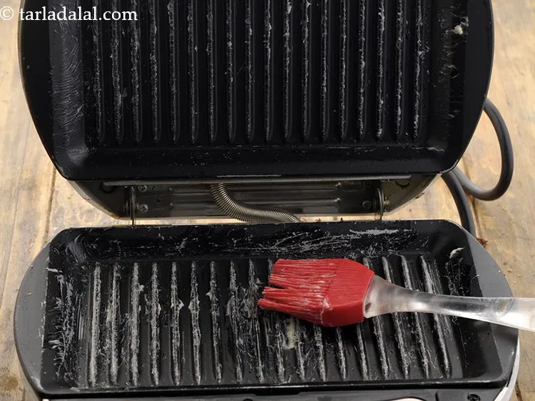 स्टेप 10 – ब्रश की मदद से ग्रिलर पर मक्खन लगा लें।