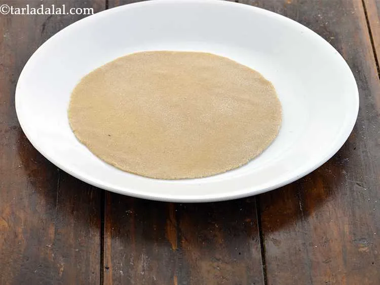 Step 15 – Sprinkle a litle flour on clean, dry surface and place the roti on it. This …