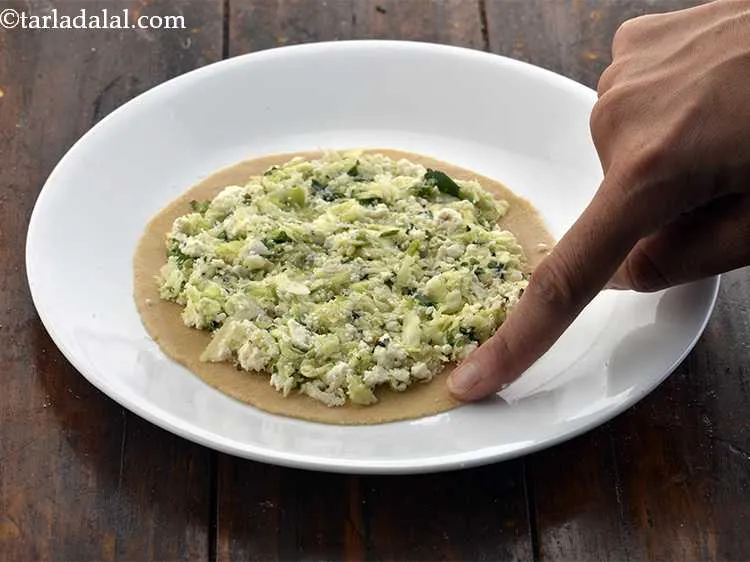 Step 17 – Dip one finger in water and apply it on the edge of the roti.