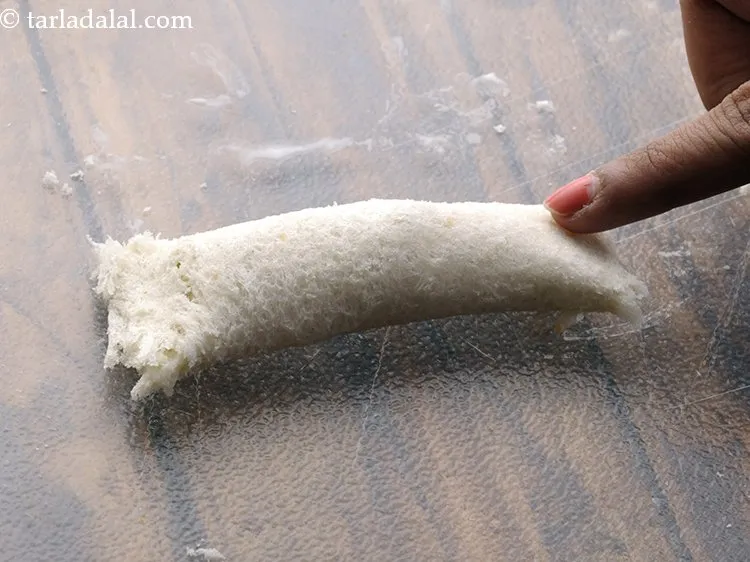 Step 20 – Apply some plain-flour water mixture on both the sides of the bread roll and press …