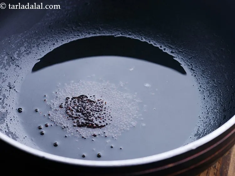 स्टेप 2 – तेल गरम होने के बाद इसमें सरसों डालें।